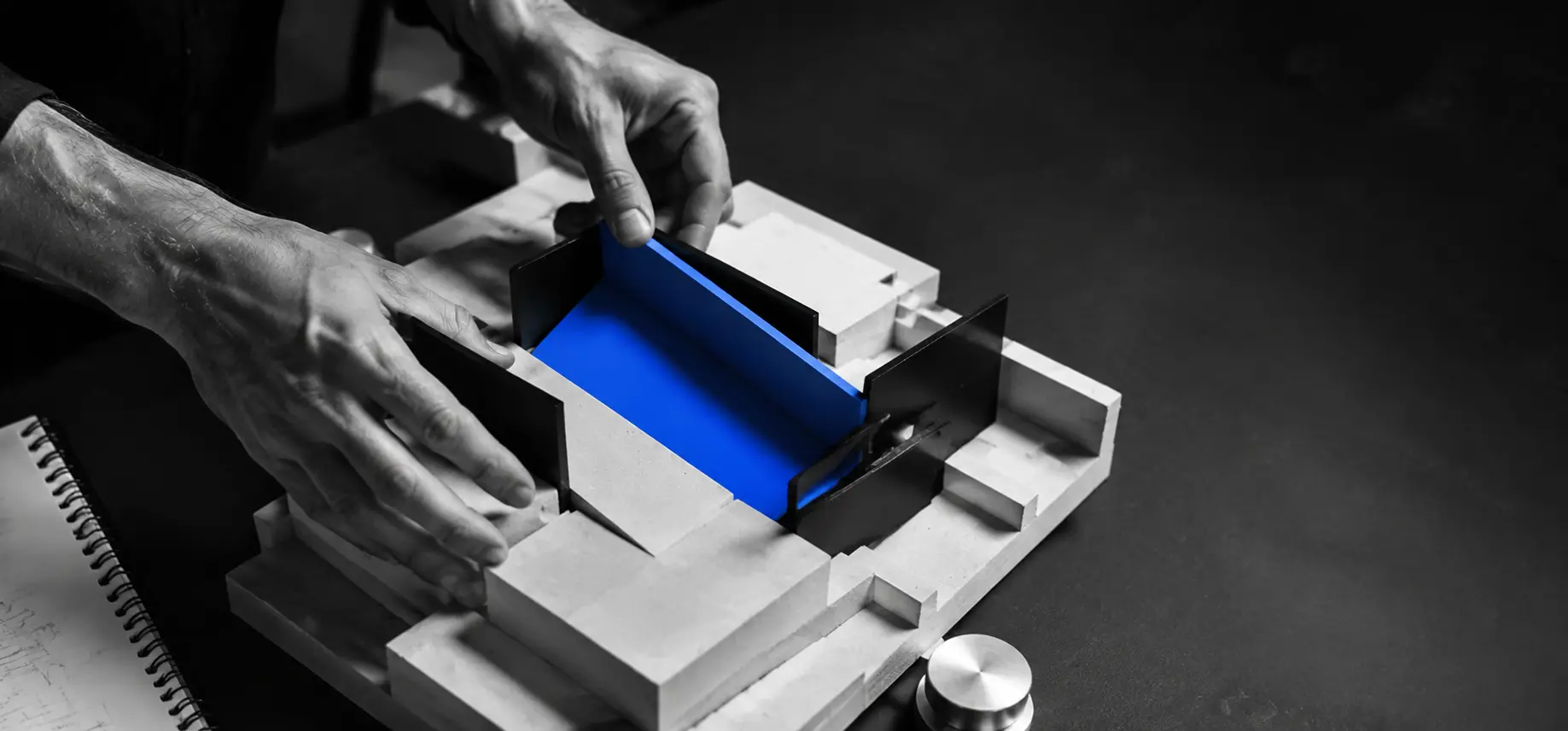 Dłonie przesuwające element mineralnego modelu firmy z niebieską płaszczyzną